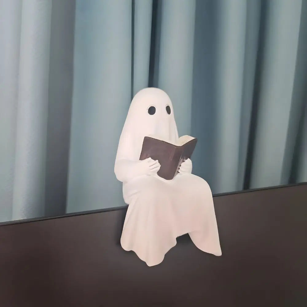 Liten spökskulptur med bok