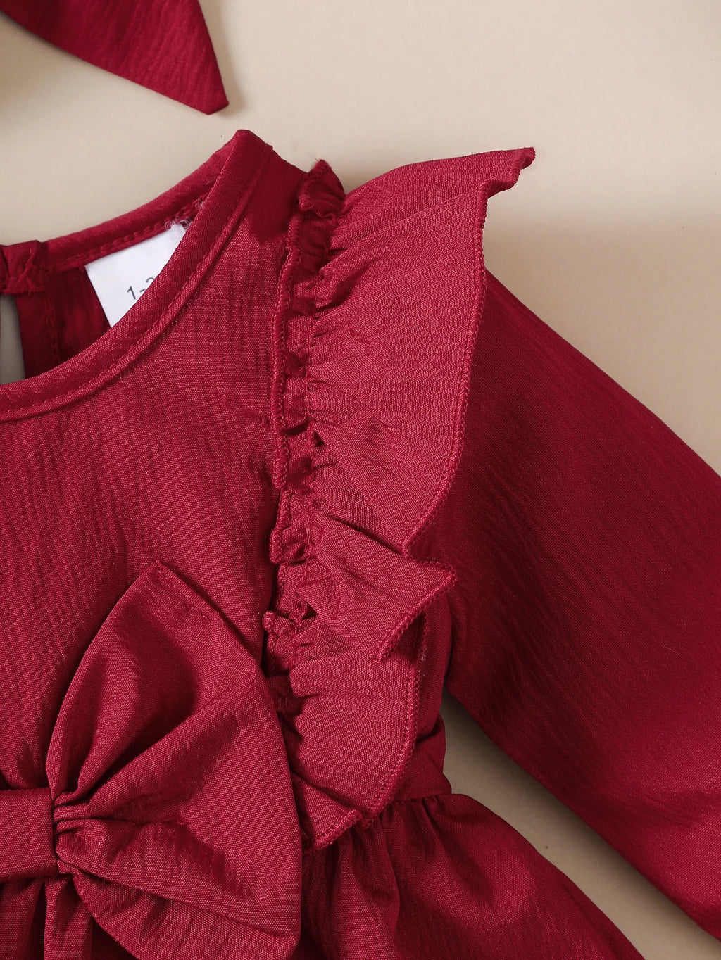 Babyklänning med volangkant & rosett